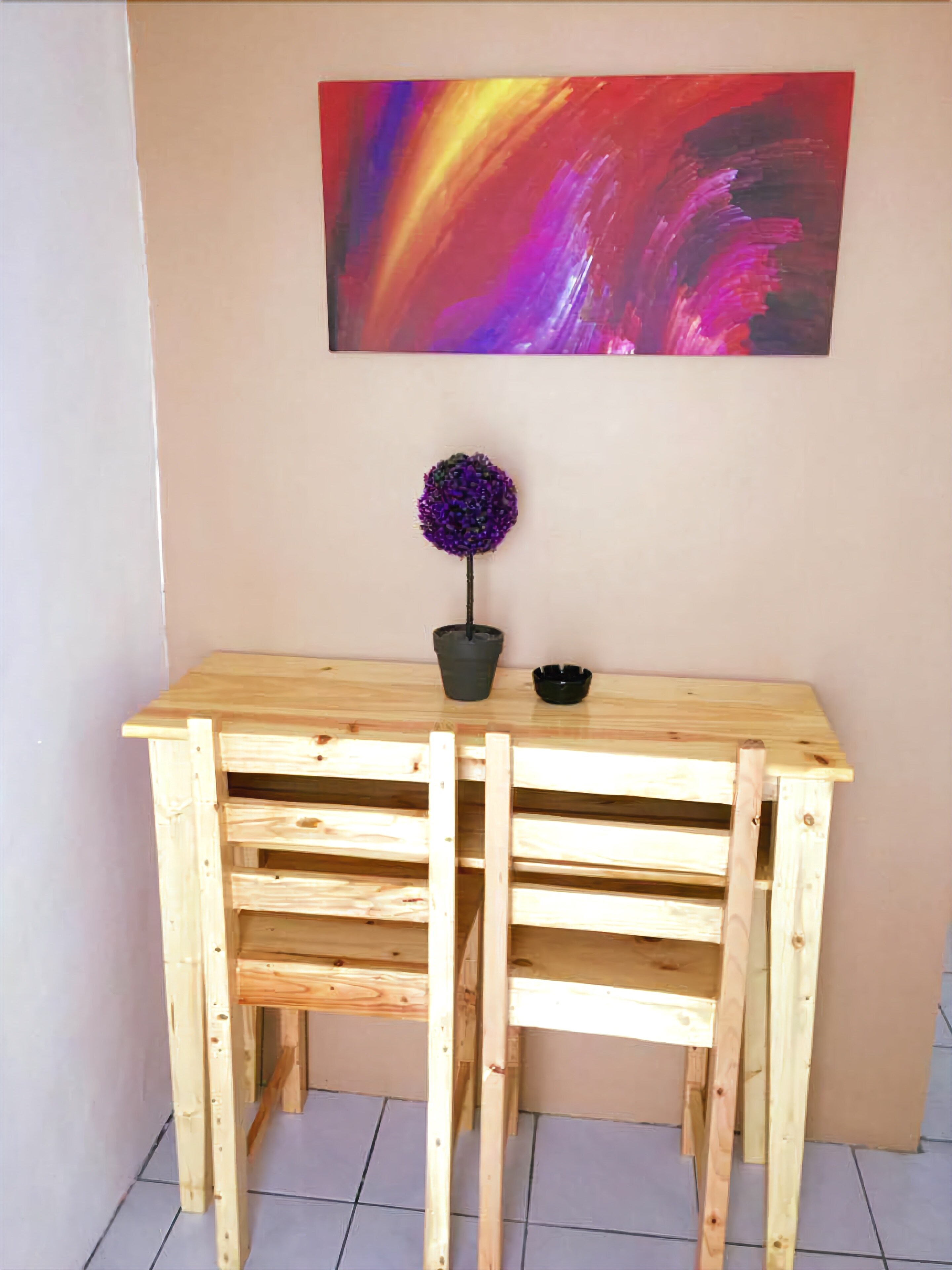 Escritorio de madera con una planta en maceta y un cuenco negro encima.