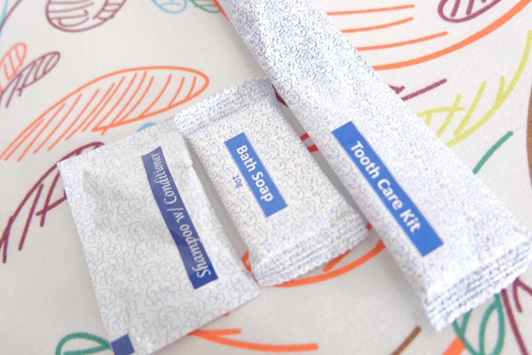 Three toiletry items: shampoo, bath soap, and a tooth care kit.