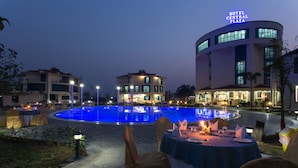 A hotel with a pool, outdoor dining area, and a sign reading "HOTEL CENTRAL PLAZA".
