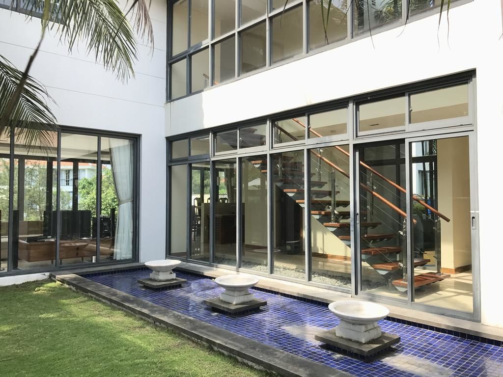 A modern building with large glass windows, a blue-tiled water feature, and a staircase leading to an upper level.
