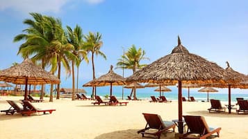 On the beach, white sand, sun loungers, beach umbrellas