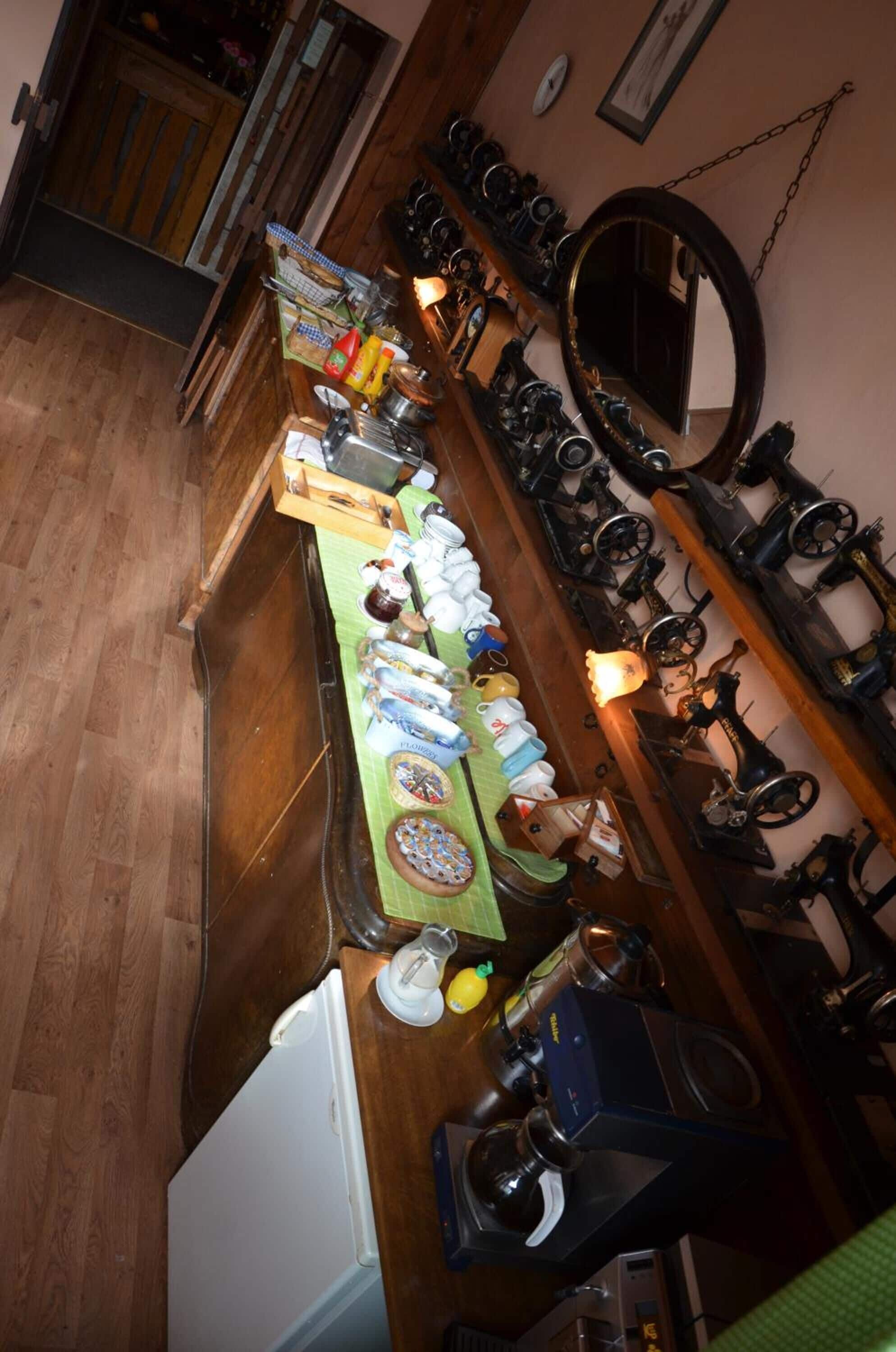 A kitchen with a long counter, various kitchen appliances, and a refrigerator.