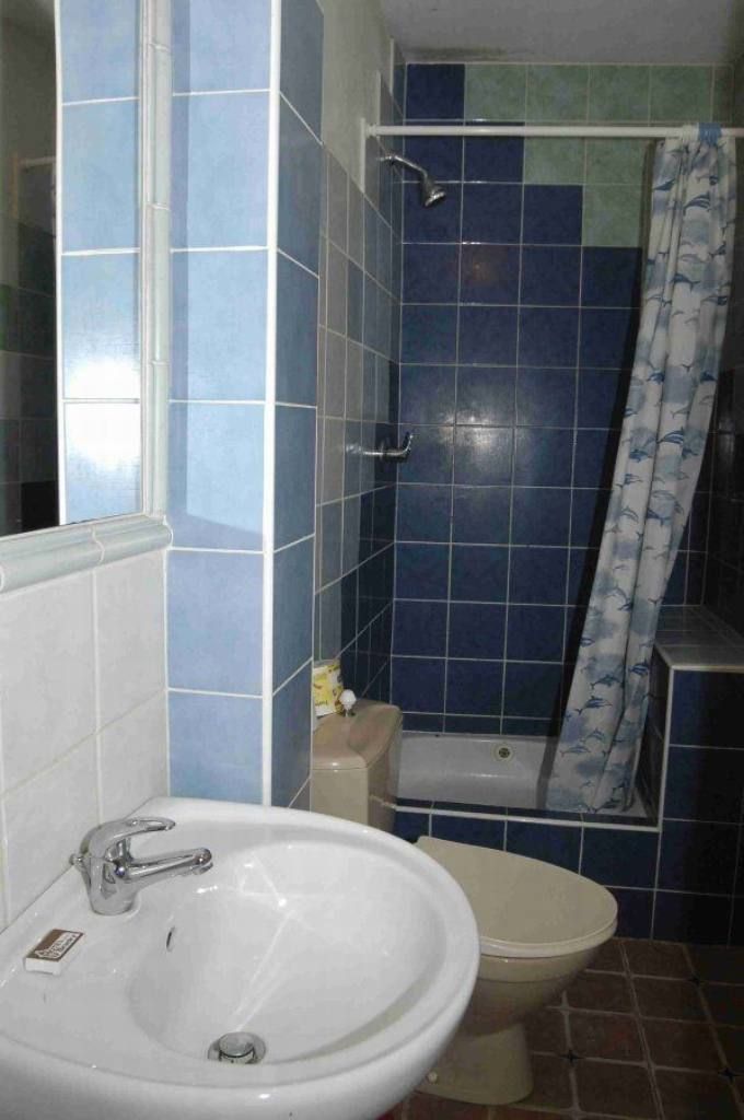 A bathroom with a sink, toilet, and shower.