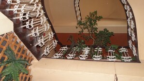 A room with a curved wooden wall, a small plant, and a decorative metal railing. - Hotel U Branky (Stribro)