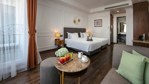 A hotel room with a bed, a small round table with breakfast, a sofa, and a bathroom visible through an open door. - Hanoi Allure Hotel (Hanoi)