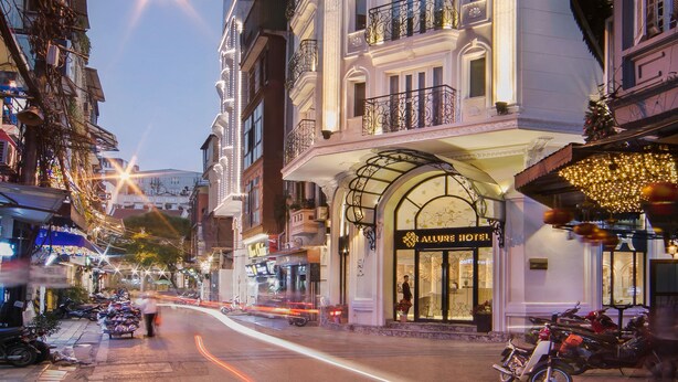 A historic building with ornate balconies and a classic facade, featuring a prominent entrance and a sign for the Allure Hotel. - Hanoi Allure Hotel (Hanoi)