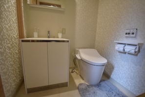Een badkamer met toilet, wastafel en handdoekhouder.