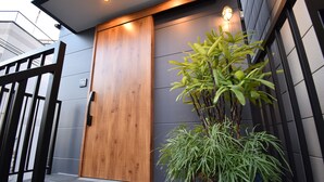 A wooden door with a modern design, a potted plant, and a gated entrance. - ieLIFE Resort HIGASHIYAMA (Kyoto)