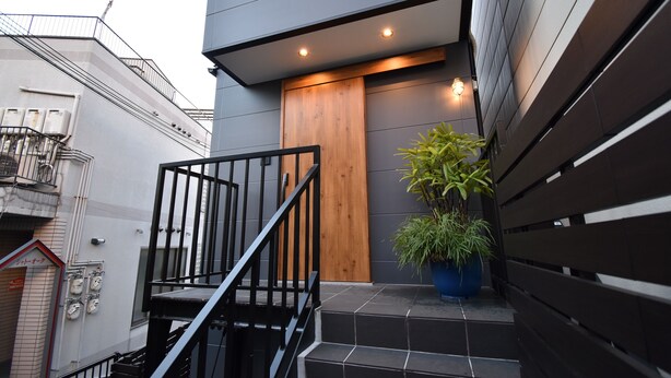A modern building with a wooden door and a staircase leading to the entrance. - ieLIFE Resort HIGASHIYAMA (Kyoto)