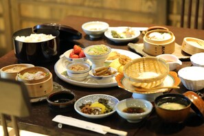 A table with various dishes, including rice, vegetables, and soup. - Shinwaen (Aso)