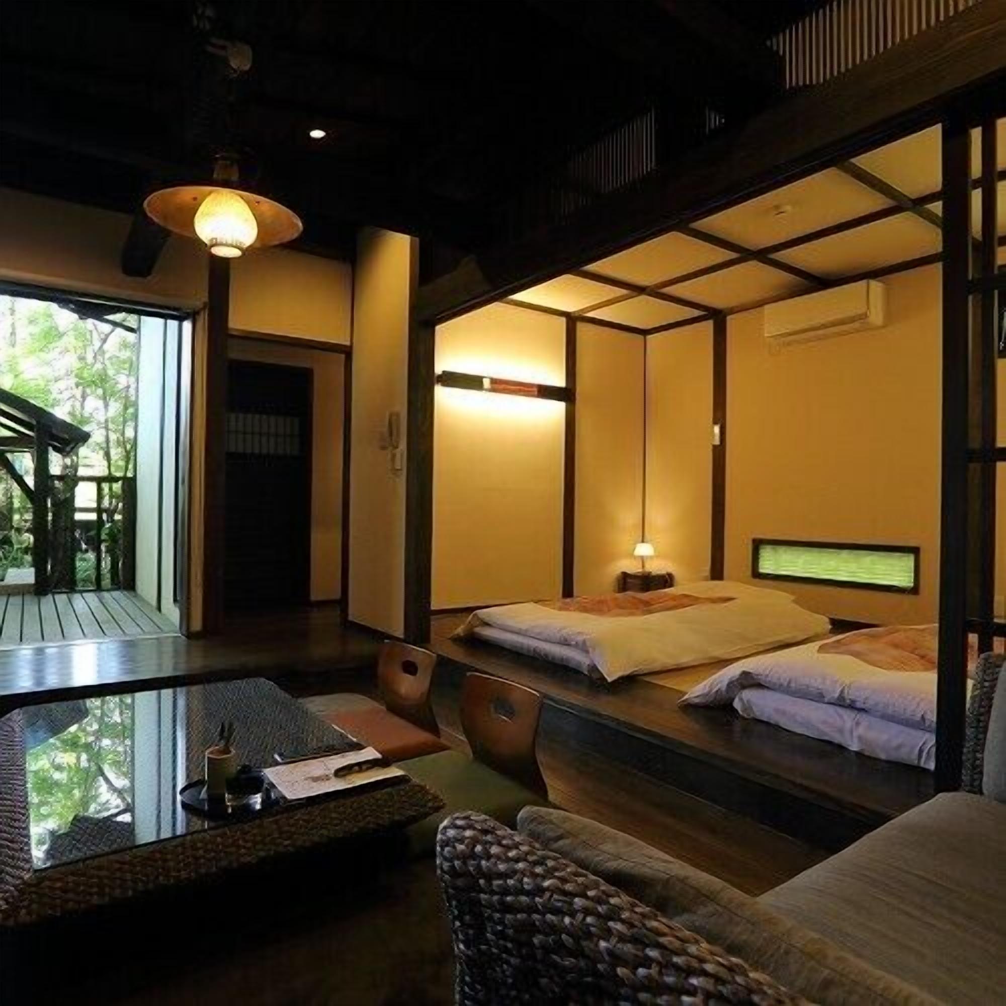A traditional Japanese-style room with tatami flooring, a low table, and a futon bed.