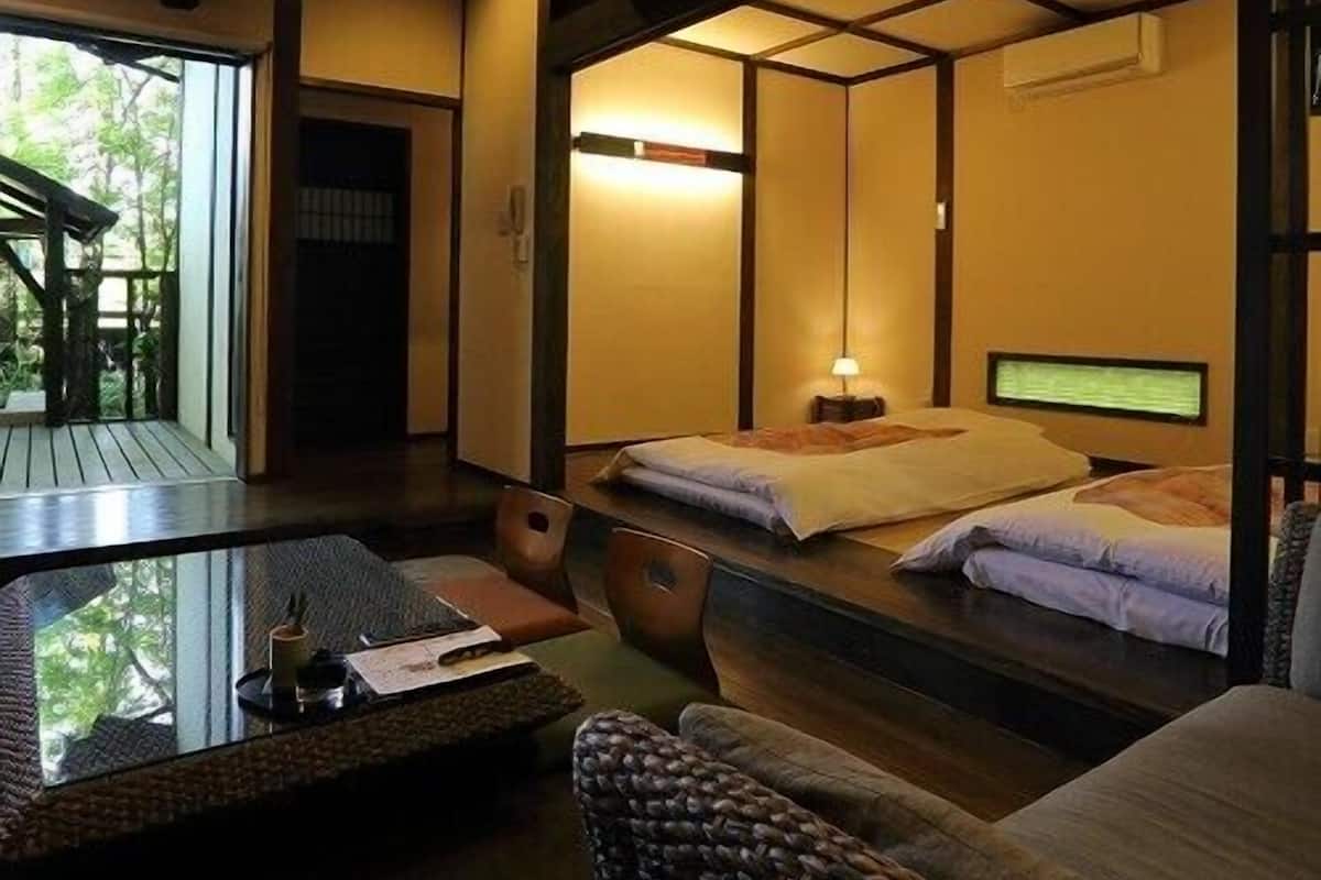 A traditional Japanese-style room with tatami flooring, a low table, and a futon bed.