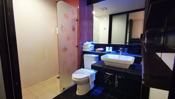 A modern bathroom with a shower, toilet, and sink.