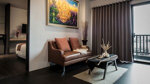 Una sala moderna con un sofá de cuero marrón, una mesa de centro y un cuadro grande en la pared.