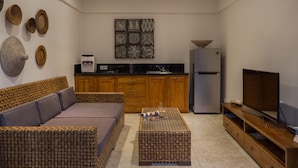 Una sala de estar moderna con sofá, mesa de centro y mueble para televisión.