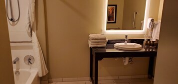 Un baño con bañera, lavabo con espejo y perchero.
