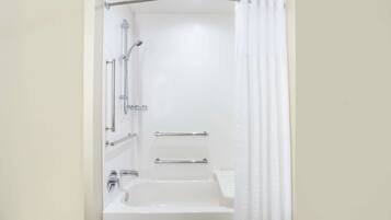 A modern bathroom with a bathtub, a shower, and a toilet.