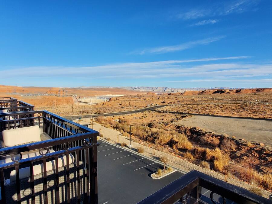 A balcony with a view of a parking lot and a desert landscape.
