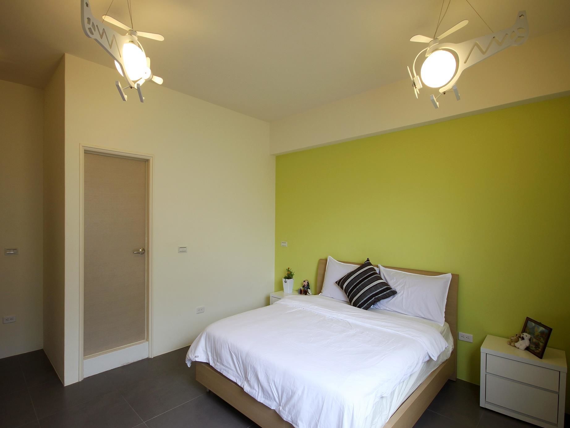 Un dormitorio con cama, mesitas de noche y ventilador de techo.
