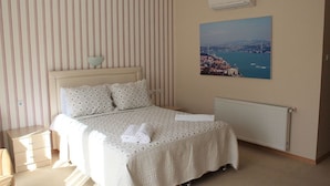 A bedroom with a bed, a nightstand, a lamp, a radiator, and a cityscape painting on the wall. - The Hotel Sapanca (Sapanca)