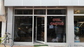 En bygning med en glasfacade og et skilt, der viser "OTEL ÇAKTUG".