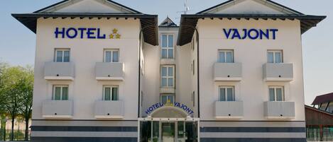 Ein Hotelgebäude mit zwei Flügeln, auf denen „HOTEL“ und „VAJONT“ steht.