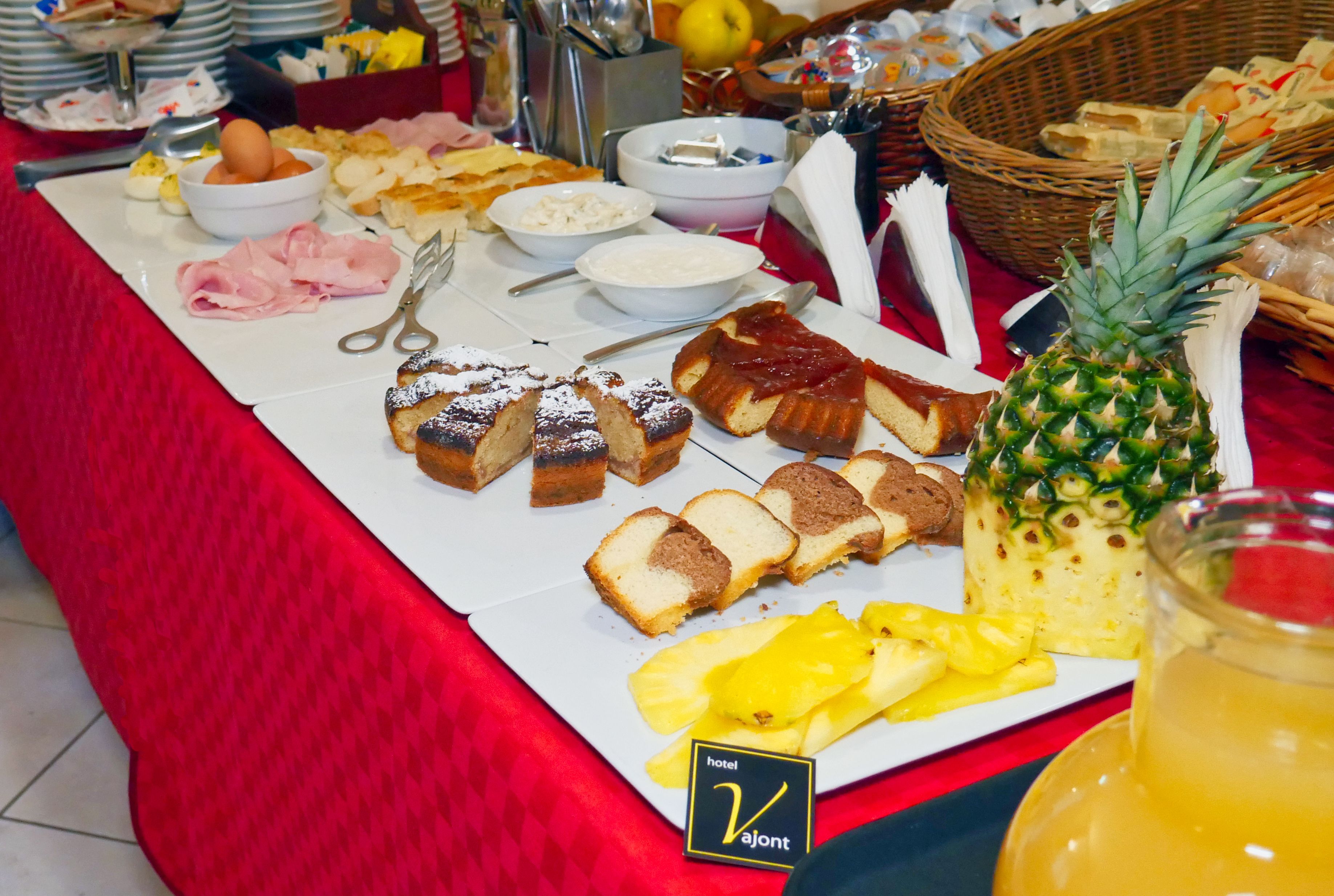 A buffet table with various food items including bread, fruit, and condiments.