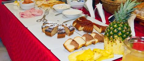 A buffet table with various food items including bread, fruit, and condiments.