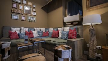 A cozy living room with a sectional sofa, a coffee table, and a lamp.