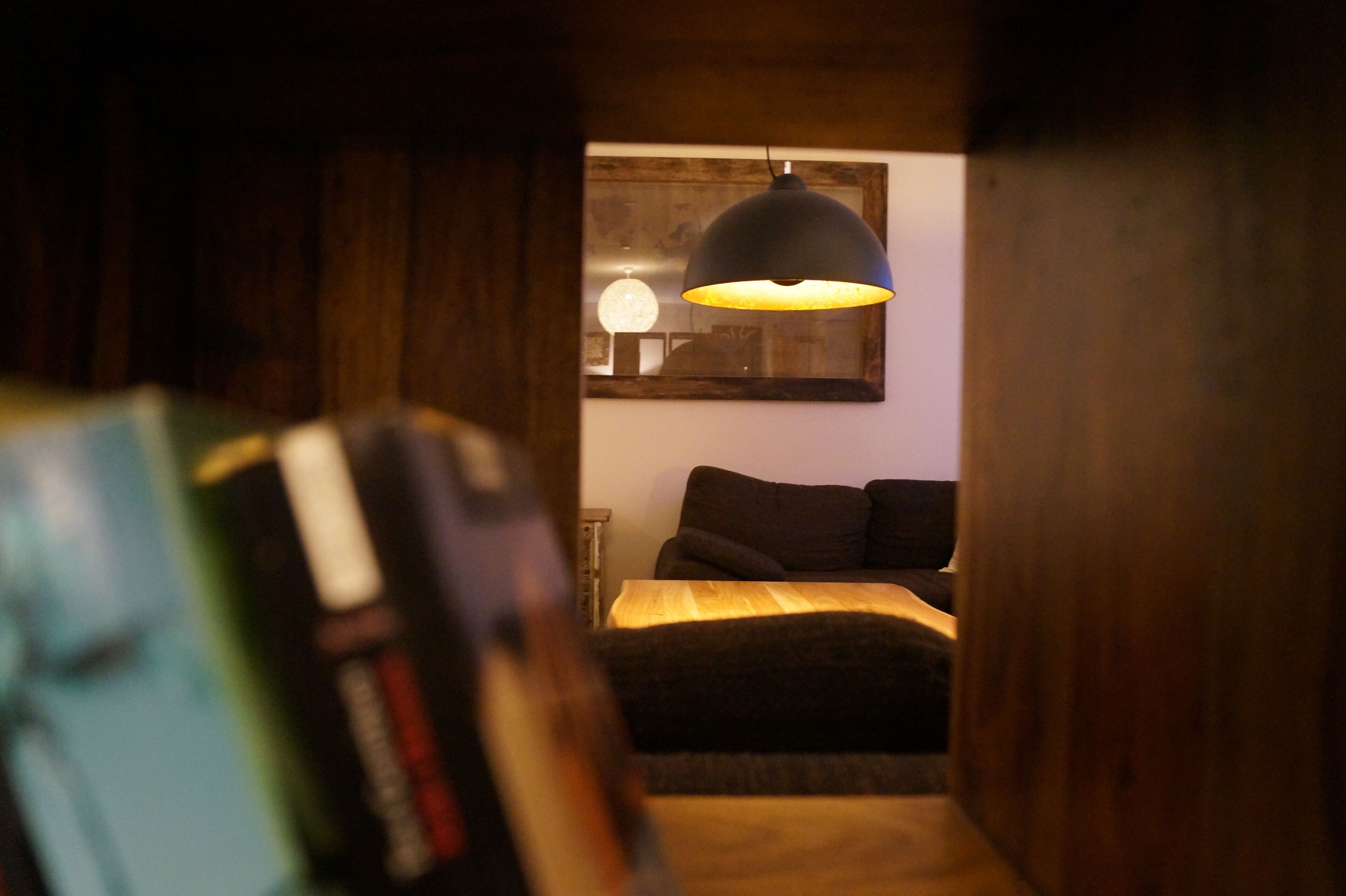 Un dormitorio con cama, lámpara colgante y un cuadro en la pared.