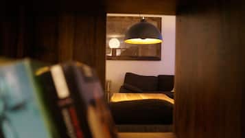 Un dormitorio con cama, lámpara colgante y un cuadro en la pared.