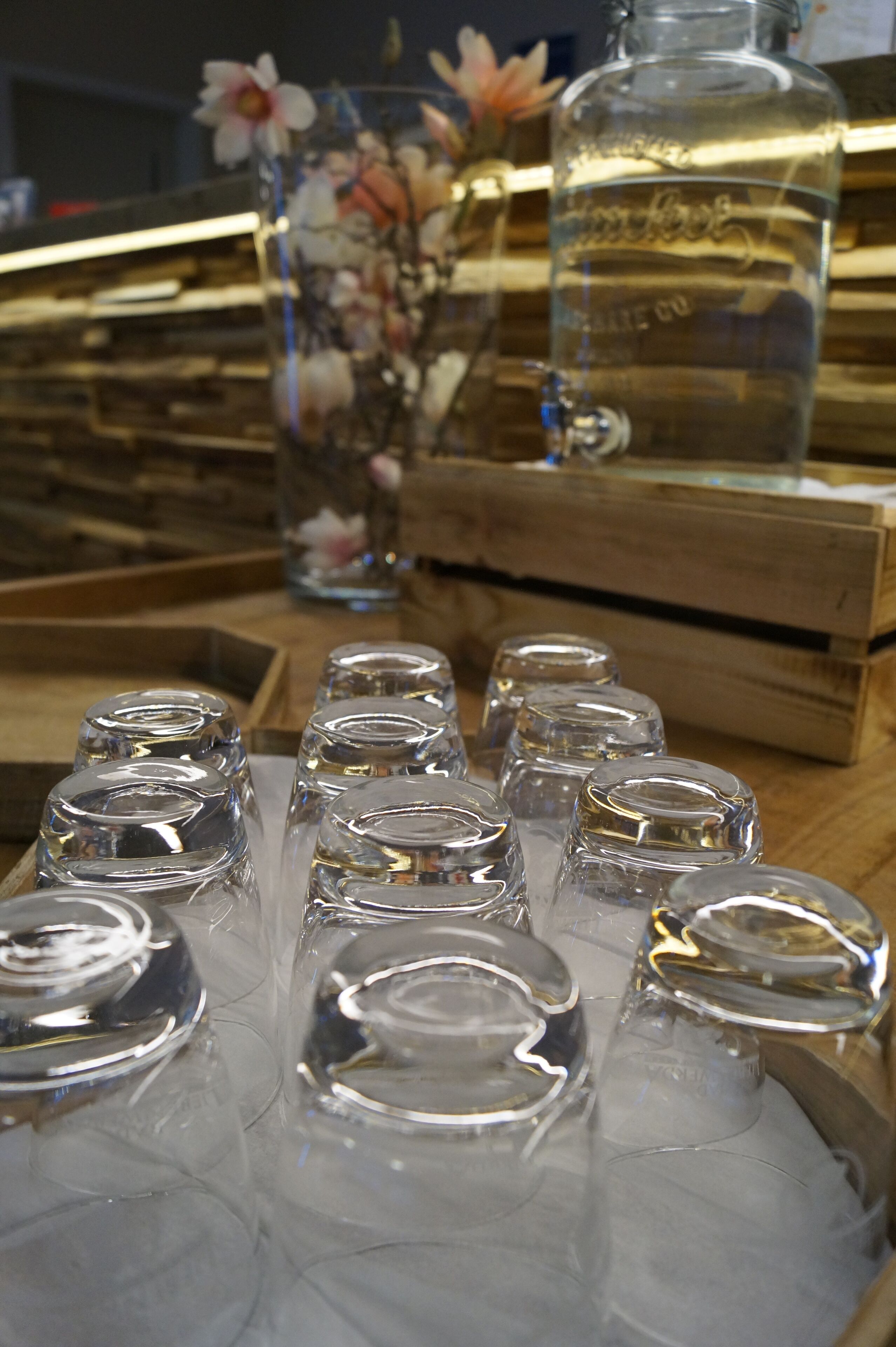 A wooden table with several clear glass bottles and a larger glass container.