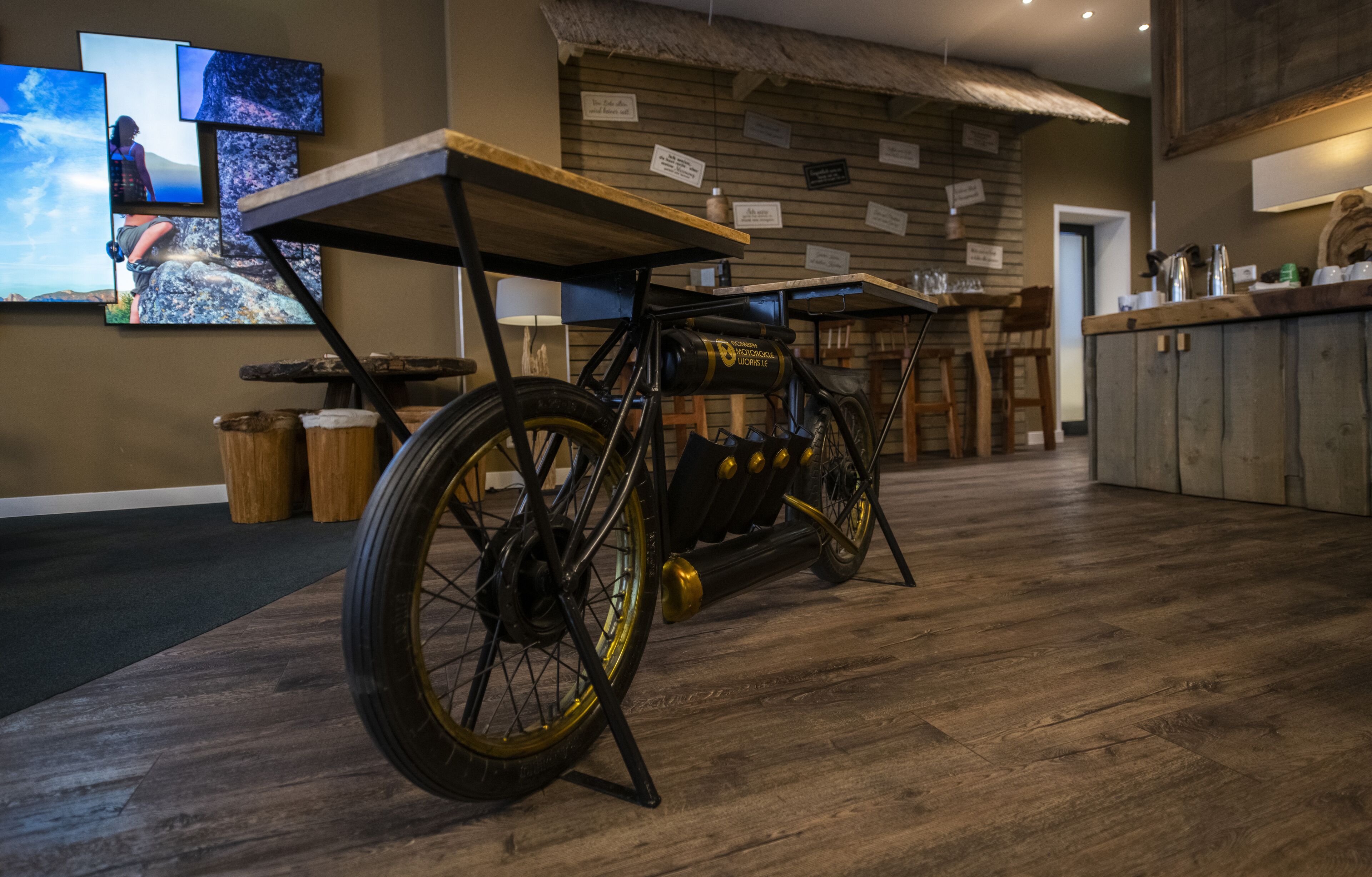 Una habitación con piso de madera, una bicicleta y una mesa.