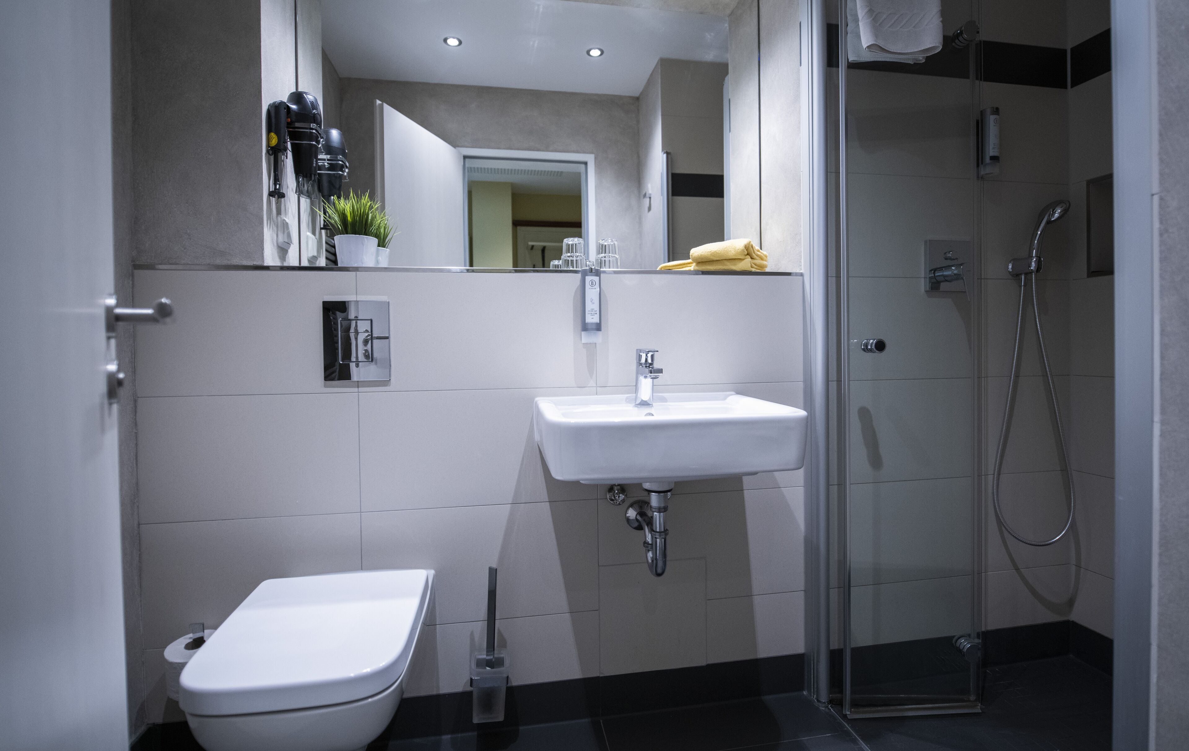 Ein modernes Badezimmer mit Toilette, Waschbecken und Dusche.