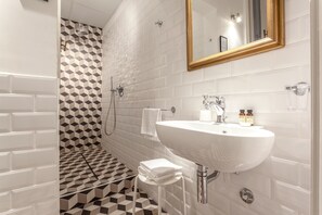 Design suite, 1 slaapkamer, keuken, uitzicht op stad | Badkamer | Een douche, gratis toiletartikelen, een haardroger, badjassen