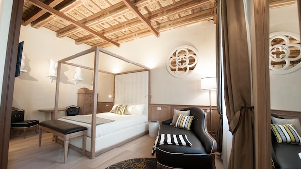A bedroom with a four-poster bed, a desk, a chair, and a sofa. - Residenza Bonifacio (Verona)