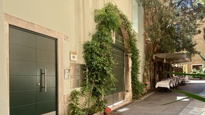 A building with a green door, potted plants, and outdoor seating. - Residenza Bonifacio (Verona)