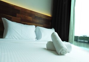A hotel room with a large bed, white linens, and a view of a body of water. - The Riverbank Hotel (Kuantan)