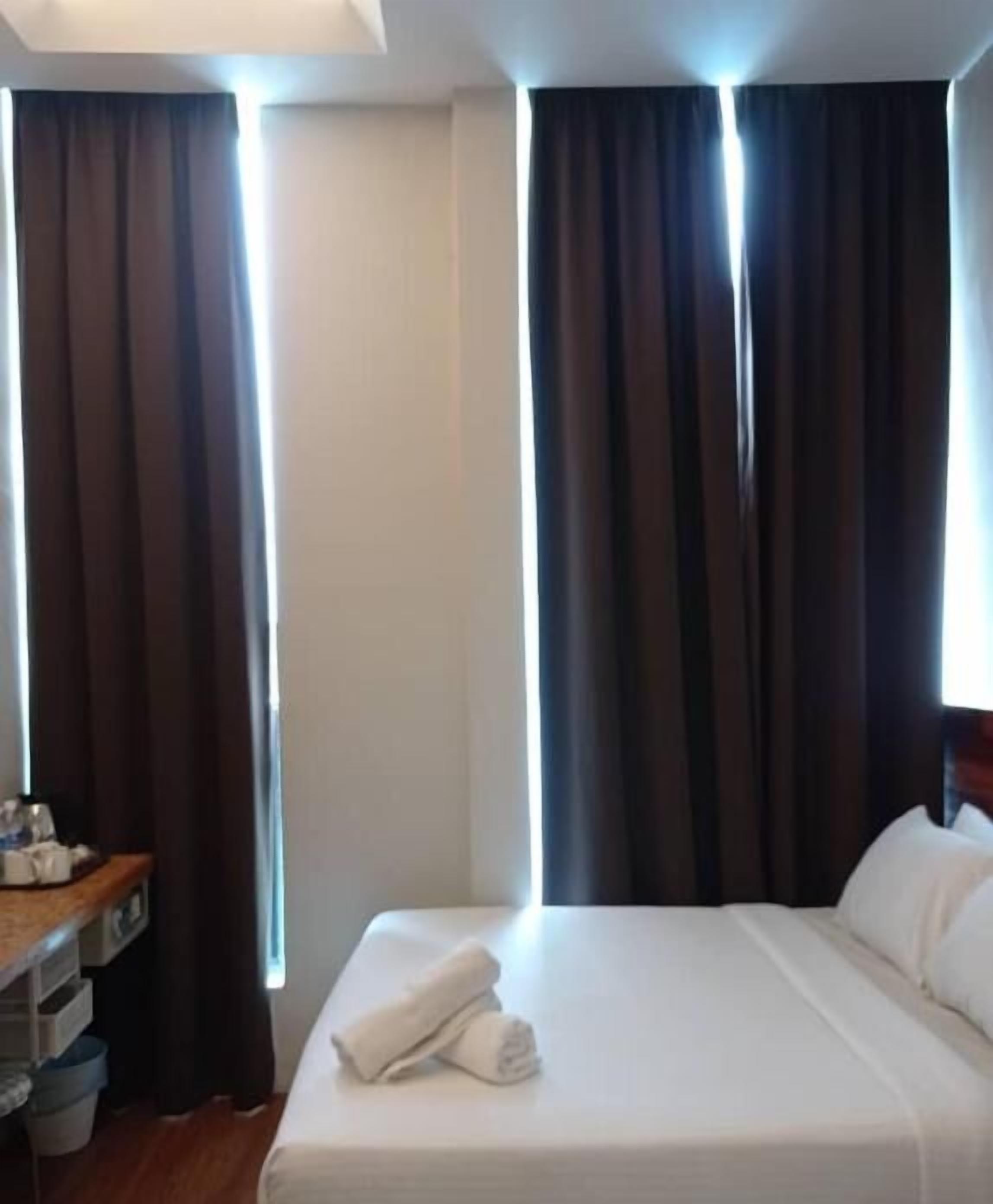 Une chambre d’hôtel avec un lit, un bureau et des rideaux.