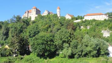 A castle on a hill with a river in the foreground.