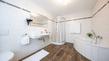A modern bathroom with a shower, sink, and toilet.