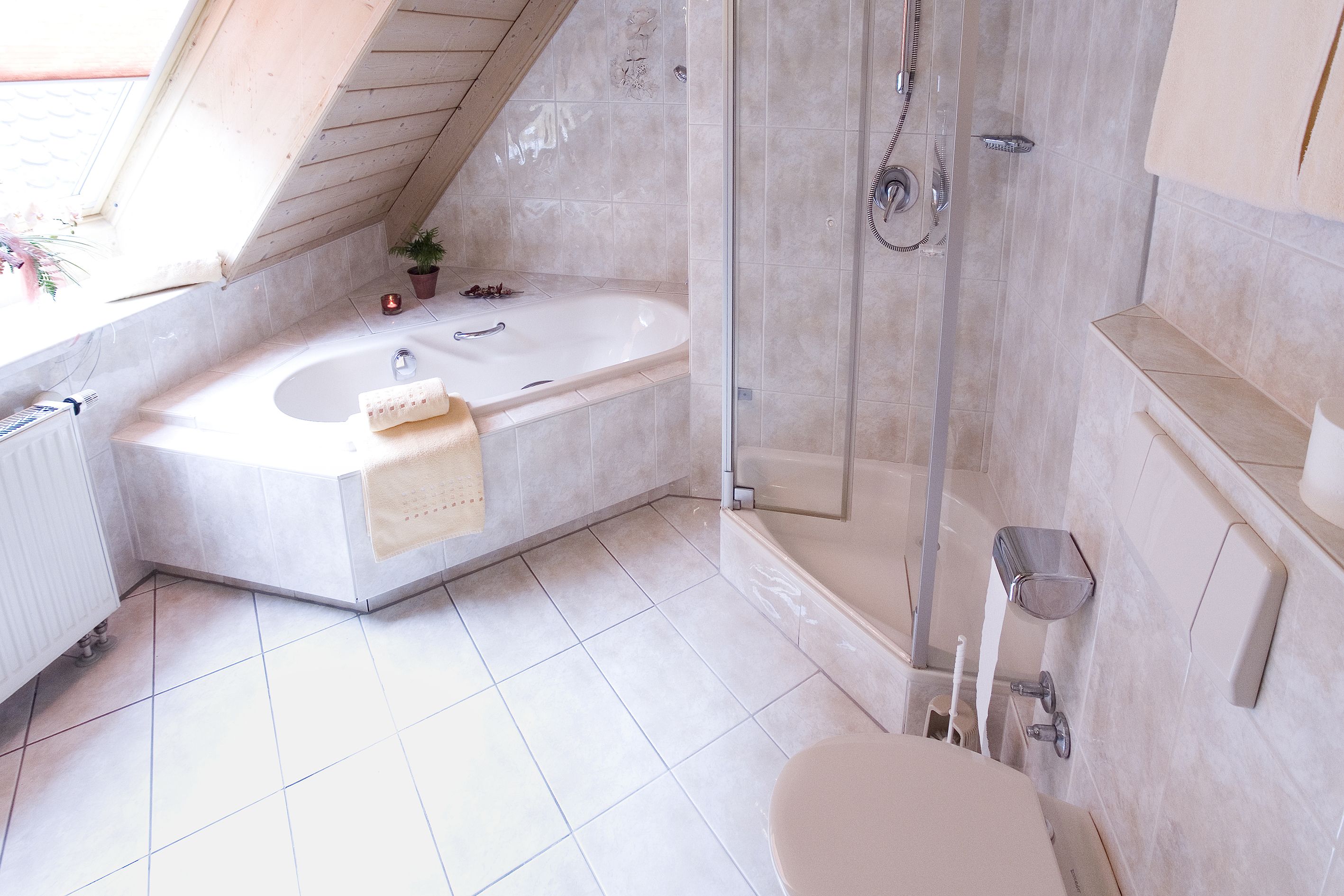 Un baño moderno con una bañera independiente, una ducha con mampara de vidrio y un inodoro.