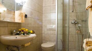 Een badkamer met een wastafel, toilet en douchecabine.