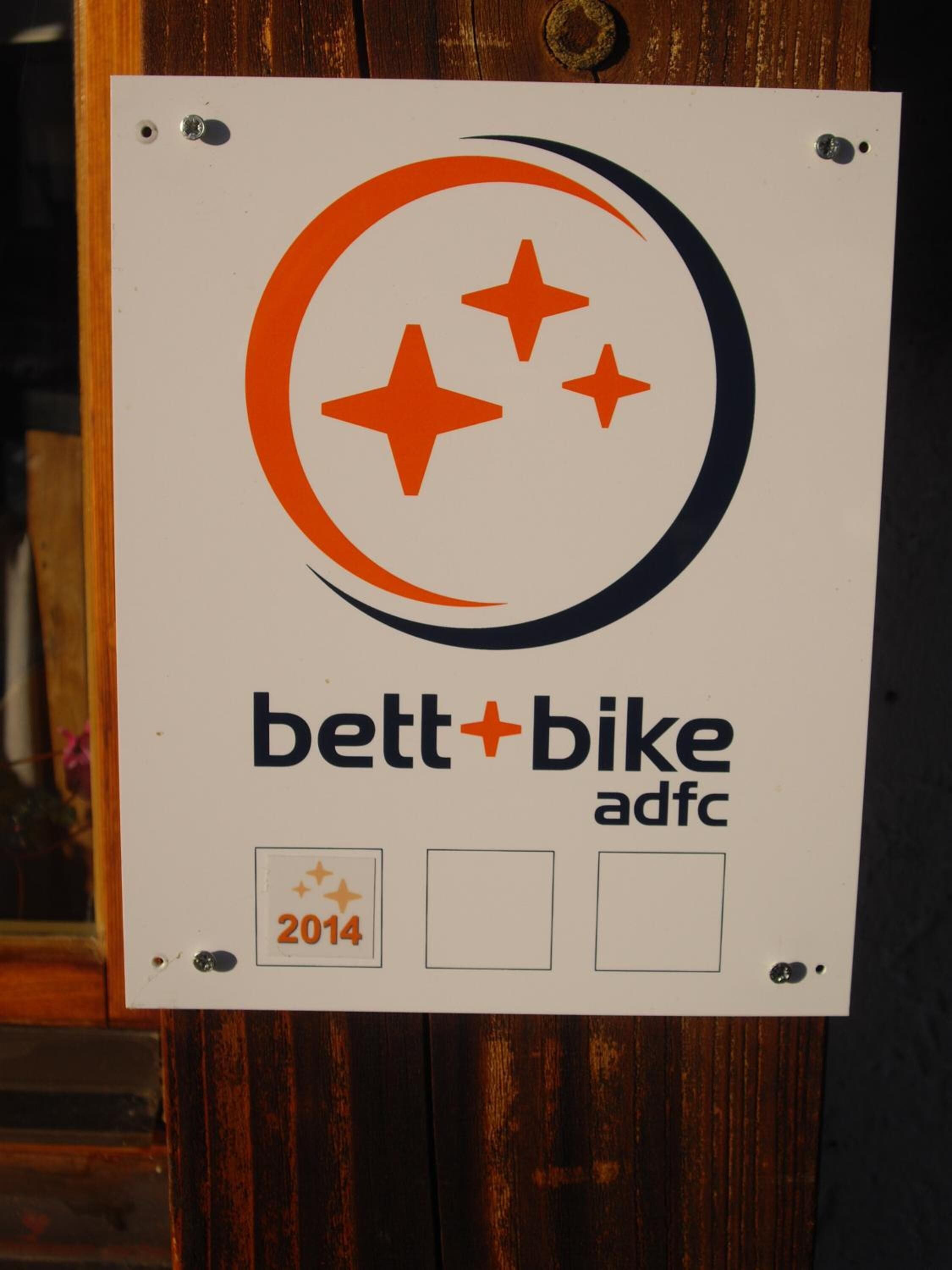A sign with a logo and text for 'bett+bike adfc' from 2014.