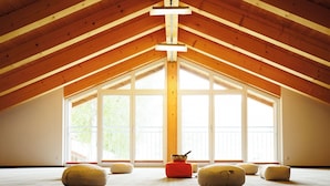Ein Dachzimmer mit Holzbalken, großen Fenstern und mehreren Sitzsäcken.