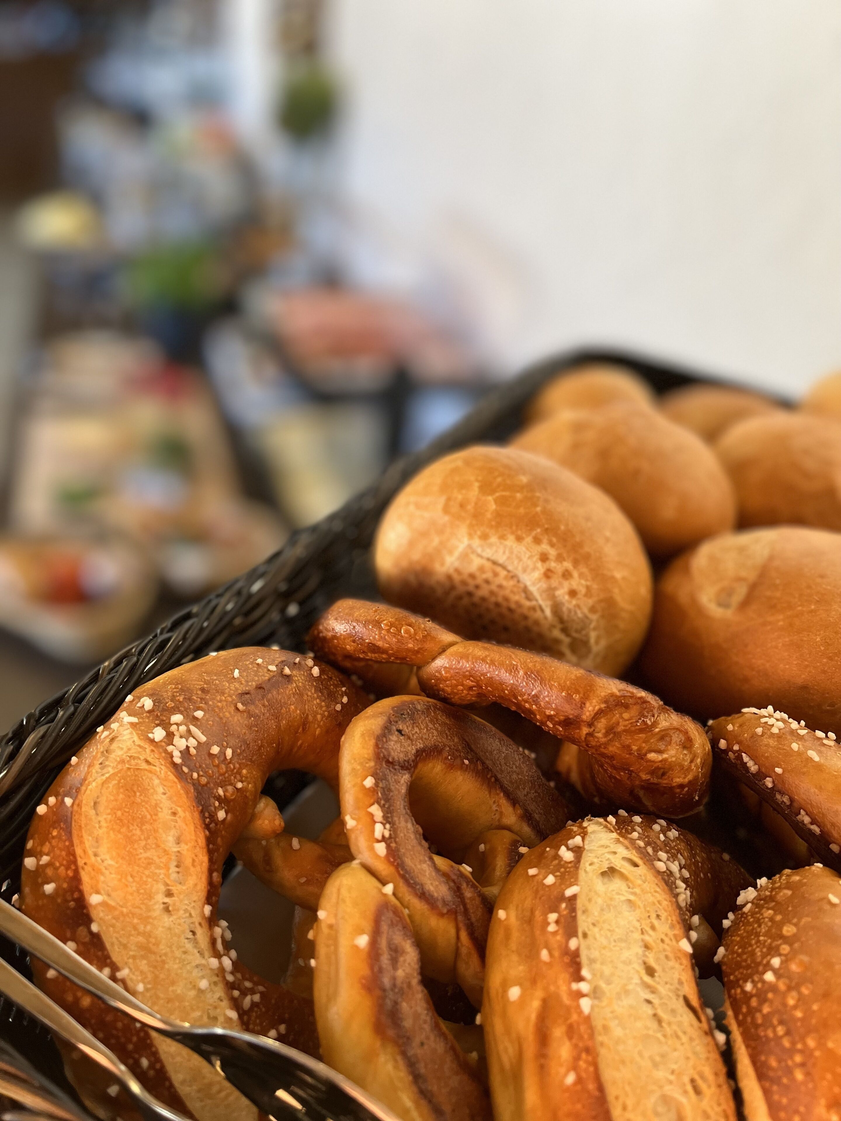 A basket of pretzels and bread rolls.