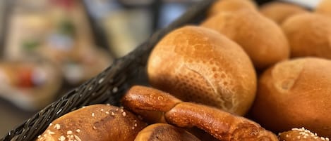 Una cesta con pretzels y panecillos.