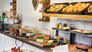 Ein Buffet mit verschiedenen Speisen, darunter Obst, Käse und Fleisch.