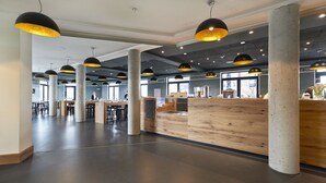 Un vaste espace intérieur doté de hauts plafonds, de piliers en béton et d’un comptoir d’accueil.