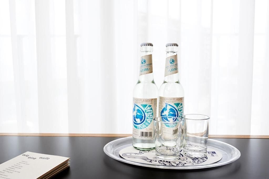 Zwei Wasserflaschen und zwei Gläser auf einem Tablett.